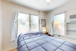ein Schlafzimmer mit einem Bett und zwei Fenstern in der Unterkunft Monsarrat Apt D - 30-Night Minimum in Honolulu