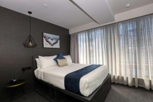 a bedroom with a bed and a large window at Microtel by Wyndham Wellington in Wellington