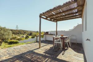 een patio met een tafel en stoelen bovenop een huis bij Aldeia da Pedralva - Slow Village in Vila do Bispo