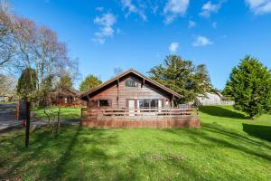 a small wooden house on a green field at Lady Galloway 28 with Hot Tub in Newton Stewart