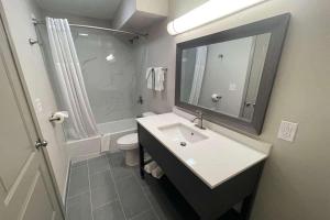 a bathroom with a sink and a toilet and a mirror at Baymont by Wyndham Dothan in Dothan