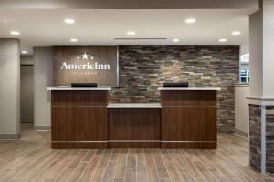 an office lobby with a sign on a brick wall at AmericInn by Wyndham San Angelo in San Angelo +64 photos