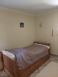 ein Schlafzimmer mit einem Holzbett in einem Zimmer in der Unterkunft Chaminés 11 in Carvoeiro