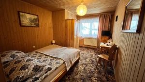 1 dormitorio con cama, escritorio y ventana en Na Dolinie, en Bukowina Tatrzańska