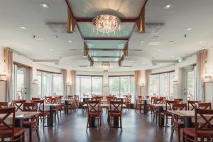 a dining room with tables and chairs and a chandelier at Holiday Club Katinkulta Superior Apartments in Vuokatti