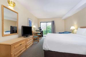 a hotel room with a bed and a television at Travelodge by Wyndham Bridgewater in Bridgewater