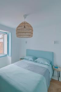 a blue bedroom with a bed and a table at Casa Azul do Olival in Alcácer do Sal