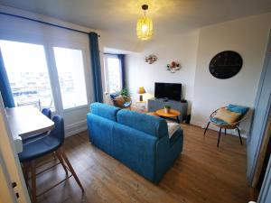 a living room with a blue couch and a table at Le Smile in Calais