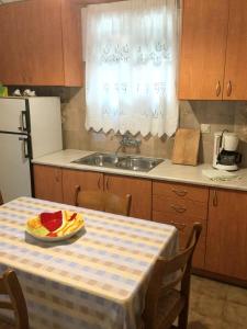 a kitchen with a table with a plate of fruit on it at ARISTIDIS APARTM. 2 in Kavos