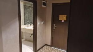 a bathroom with a sink and a door with a mirror at Suite Roma 1 at Royal Spa in Velingrad +38 photos