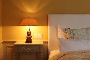 een lamp op een tafel naast een bed bij Biberhues-EG in Archsum