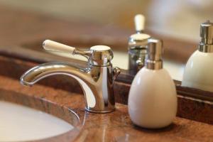 een wastafel in de badkamer met een kraan en een fles zeep bij Biberhues-EG in Archsum