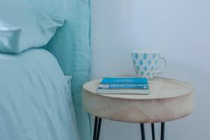 a table with a cup on it next to a bed at Casa Azul do Olival in Alcácer do Sal
