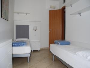Habitación pequeña con 2 camas y armario en Bright apartment with swimming pool - Beahost en Bibione