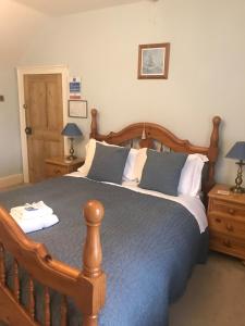 a bedroom with a wooden bed and two night stands at The Post House in Ibstock