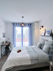 Un dormitorio con una cama grande y una ventana en LA MASCOTTE en Saint-Louis