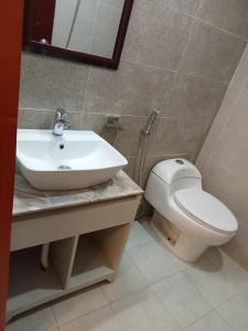 a bathroom with a white toilet and a sink at D' more Sajek Valley Hotel & Resort in Māhmuam