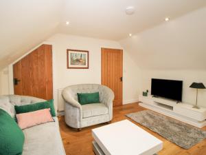 a living room with a couch and a tv at Stable Cottage in Bishops Castle