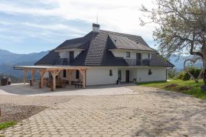 une maison avec un toit en gambrel et une terrasse dans l'établissement Vila Marin, à Prevalje