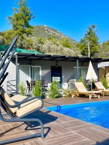 a house with a pool and a lounge chair next to a house at Santana Villas in Göcek