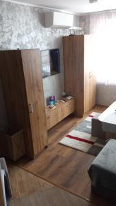 a living room with wooden cabinets and a flat screen tv at Студио Еми in Chepelare