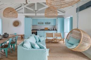 a living room with a swing chair and a table at Casa Azul do Olival in Alcácer do Sal +9 photos