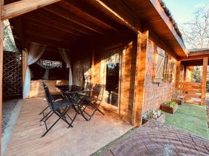 a porch of a house with a table and chairs at Chalet bois jacuzzi in Bessan