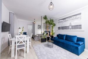 a living room with a blue couch and a table at Apartamenty Rodzinne in Kołobrzeg