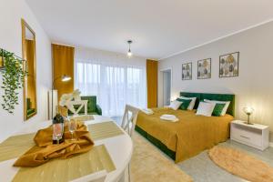 a bedroom with a bed and a table and a dining room at Apartamenty Rodzinne in Kołobrzeg