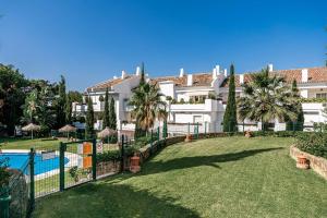 un gran edificio blanco con piscina y patio en Great Location, Spacious And Beautiful Apartment, en Marbella