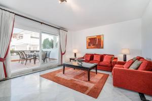 a living room with a red couch and a table at Great Location, Spacious And Beautiful Apartment in Marbella