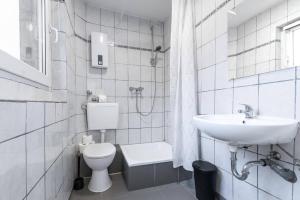 a white bathroom with a sink and a toilet at T&K Apartments - Duisburg - 4 Rooms Apartment - 2nd Floor in Duisburg