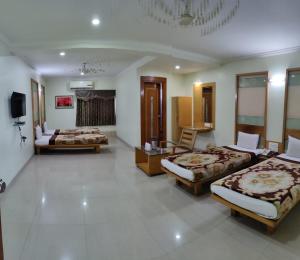 a hotel room with three beds and a television at Hotel Easy Retreat in Vapi
