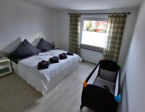 1 dormitorio con cama, ventana y maleta en Apartment Weißer Burgunder, en Bad Sachsa