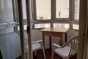 una mesa pequeña y sillas en una habitación con ventanas en Departamento en el centro de Rosario en Rosario