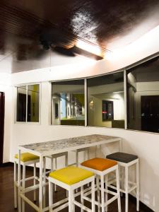 a kitchen with a counter with stools and windows at Corazon Tourist Inn in Puerto Princesa City