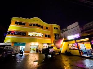 a yellow building with a car parked in front of it at Corazon Tourist Inn in Puerto Princesa City