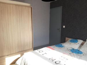 呂翁的住宿－Ombre d'été，一间卧室配有一张床和一个木制橱柜