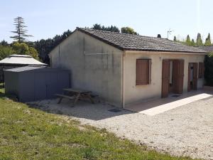 ein kleines Gebäude mit einem Picknicktisch davor in der Unterkunft Ombre d'été in Ruoms