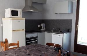 eine kleine Küche mit einem Tisch und einer Mikrowelle in der Unterkunft Ombre d'été in Ruoms