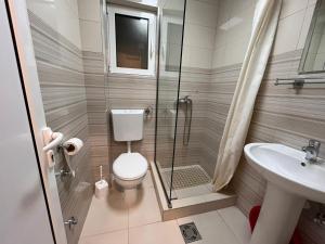 a bathroom with a shower and a toilet and a sink at Pearl Apartments in Budva
