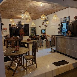 a restaurant with tables and people sitting in a room at Padang-Padang Sari Homestay in Uluwatu