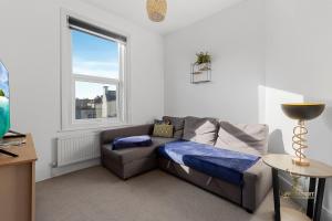 ein Wohnzimmer mit einer Couch und einem Fenster in der Unterkunft Central Exeter Apartment (Kimberley 1A) in Exeter