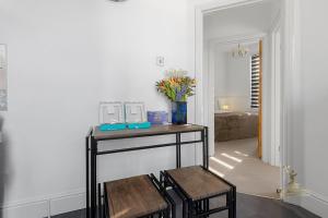 a room with a table with two chairs and a vase of flowers at Central Exeter Apartment (Kimberley 1A) in Exeter