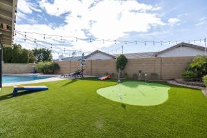 een tuin met een putting green en een zwembad bij Gilbert Harwell home in Breckenridge Manor