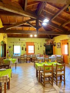 een restaurant met tafels en stoelen met groene tafels bij Agriturismo Su Niu in Uta