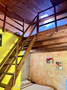 uma escada de madeira num quarto com uma cama em Agriturismo Su Niu em Uta