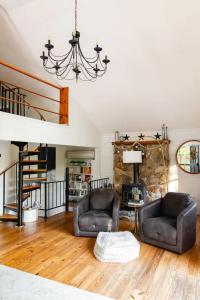 a living room with two chairs and a fireplace at HOT TUB Charming & Chic Mountain Gem On Sleepy Creek in Berkeley Springs