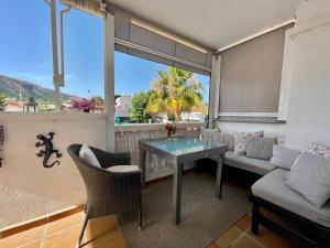 een woonkamer met een tafel en een bank bij Appartement Primavera in Alfaz del Pi