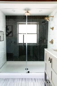 a bathroom with a shower with a glass door at HOT TUB Charming & Chic Mountain Gem On Sleepy Creek in Berkeley Springs